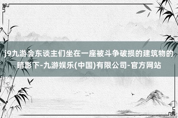 j9九游会东谈主们坐在一座被斗争破损的建筑物的暗影下-九游娱乐(中国)有限公司-官方网站